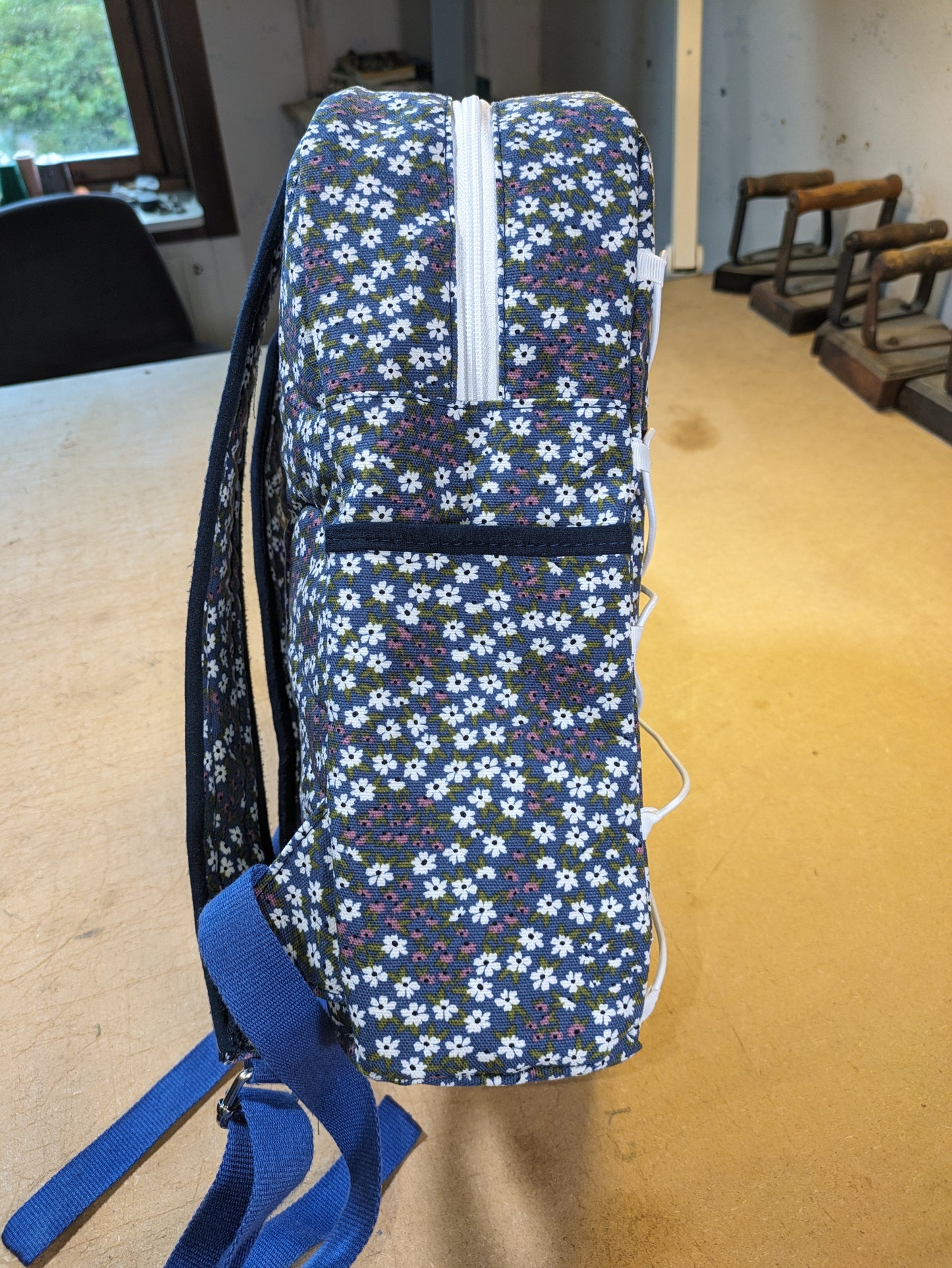 Blue backpack with floral pattern and white zippers