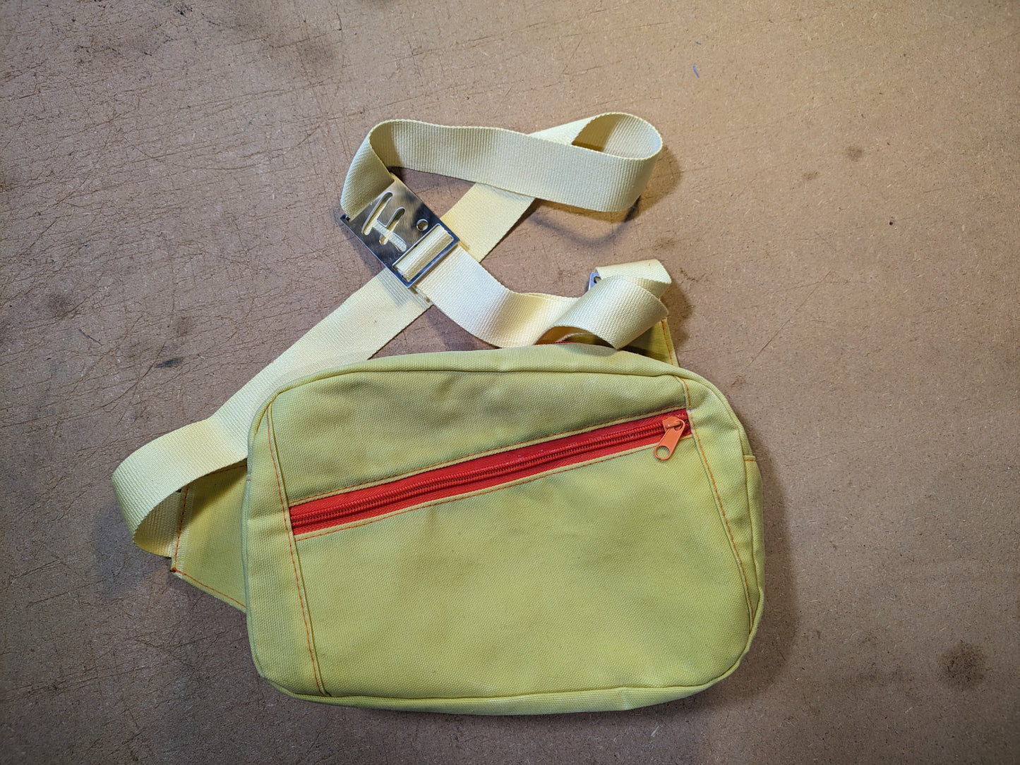 Mini sling bag in lemon yellow with matching strap and orange thread and zippers