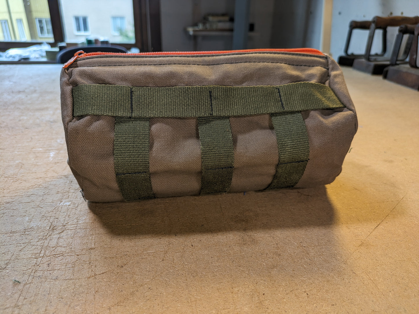 Drab/Khaki handlebar bag with black webbing, orange zipper and flexcord