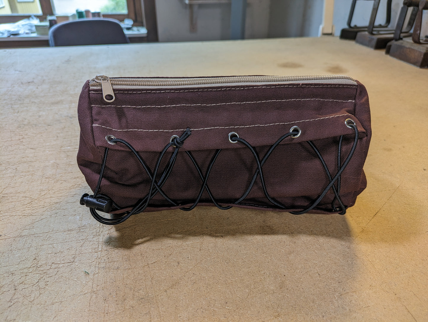 Burgundy handlebar bag with beige webbing and flexcord