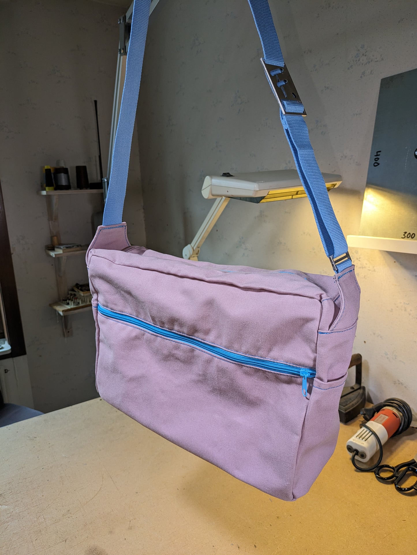 Shoulder bag in old pink with light blue zippers and strap