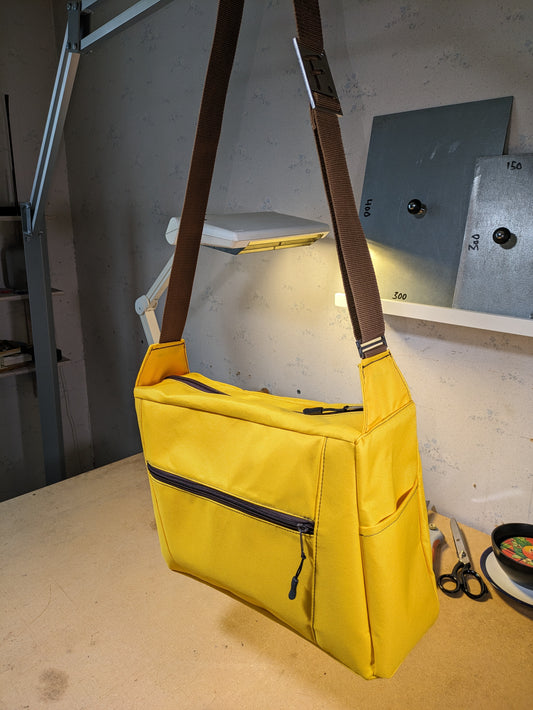 Shoulder bag in yellow Cordura nylon with brown zippers and strap