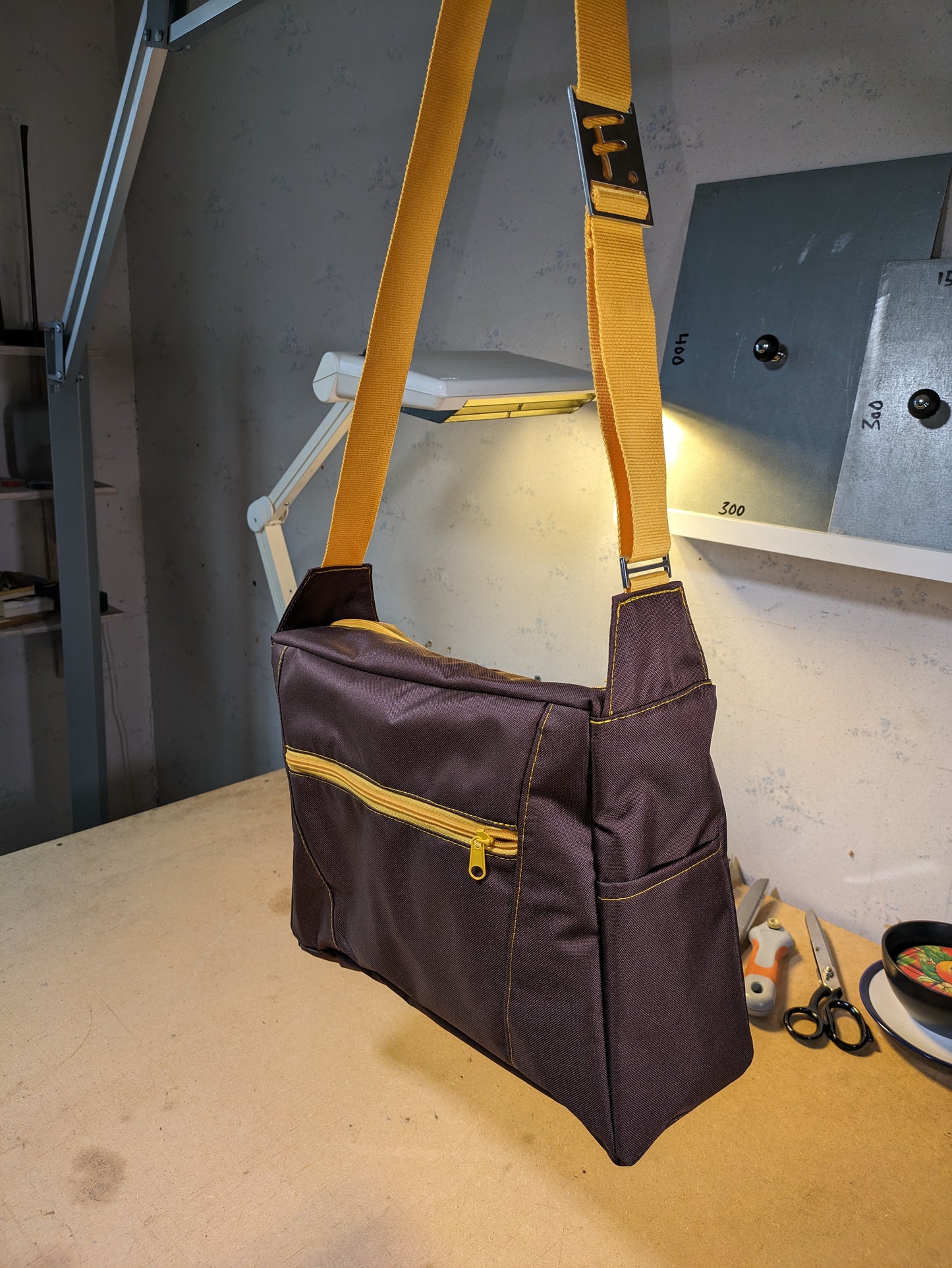 Brown shoulder bag with yellow zippers and strap