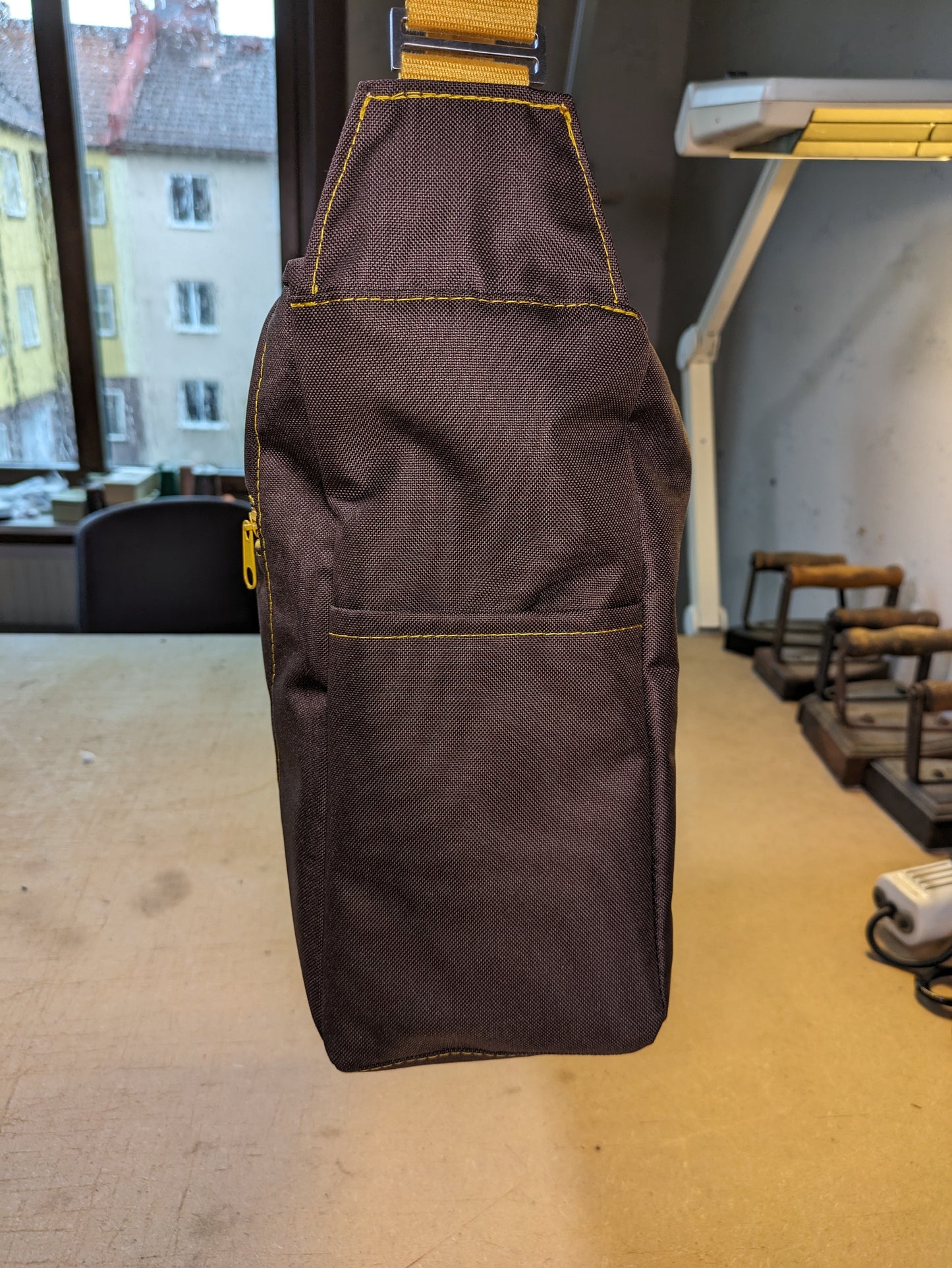 Brown shoulder bag with yellow zippers and strap