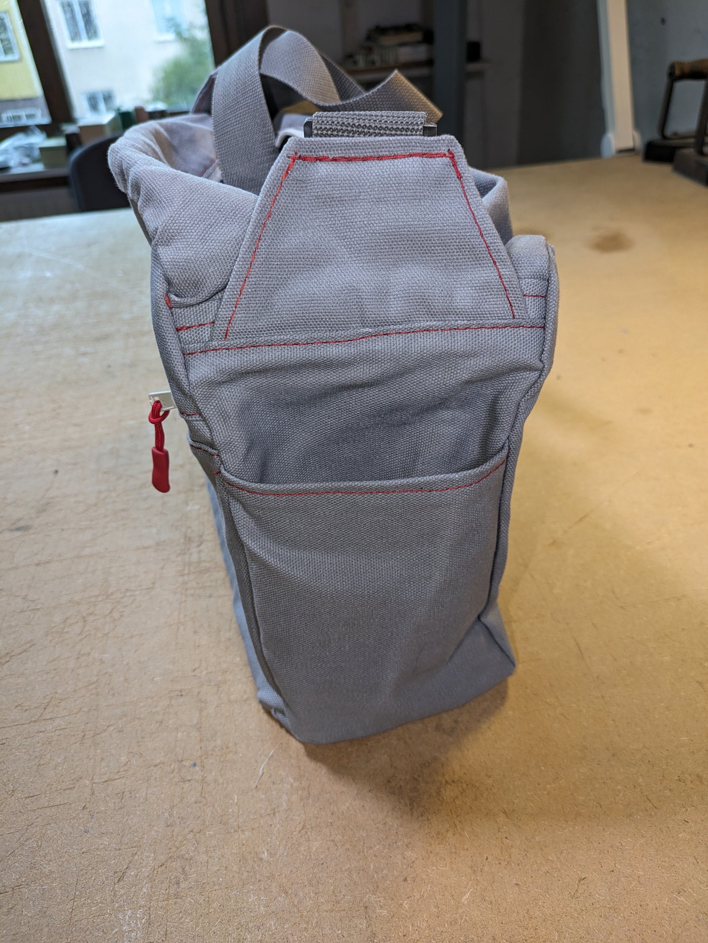 Shoulder bag in gray with white zippers, red thread and gray strap